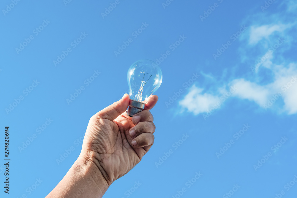 hand holding light bulb and blue sky background