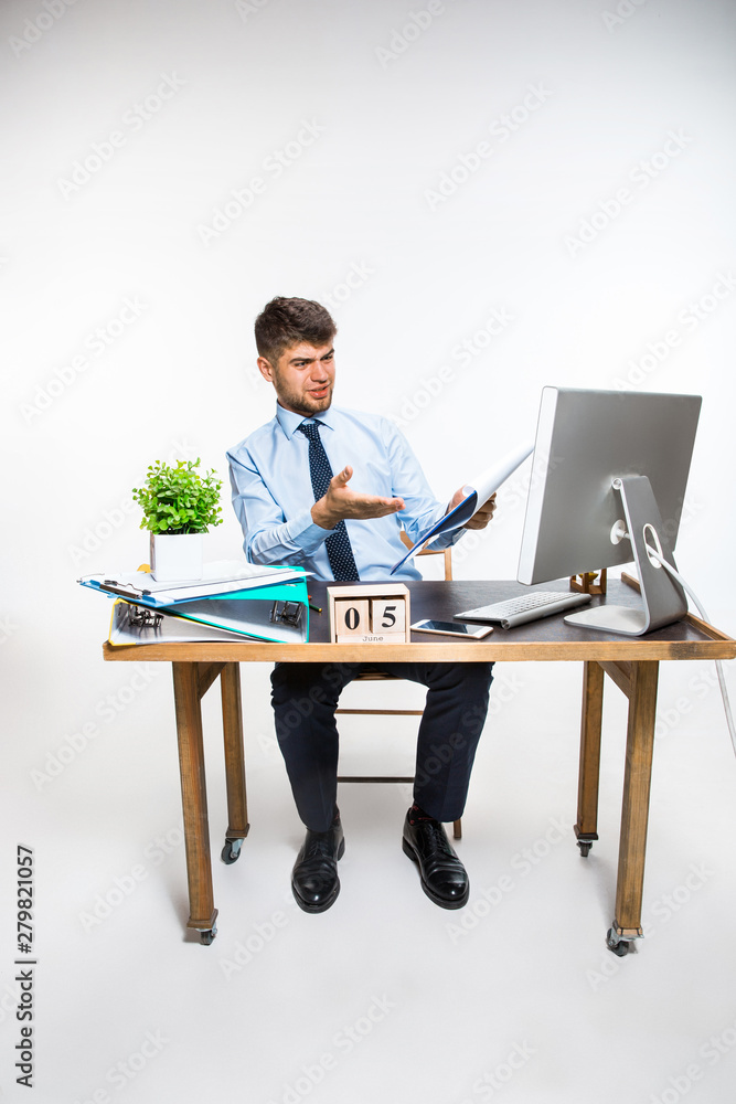 The young man getting awful, shocking message. Can't believe his eyes, loses his balance in shock, getting upset and angry. Concept of office worker's troubles, business, information problems. The young man getting awful, shocking message. Can't believe his eyes, loses his balance in shock, getting upset and angry. Concept of office worker's troubles, business, information problems.