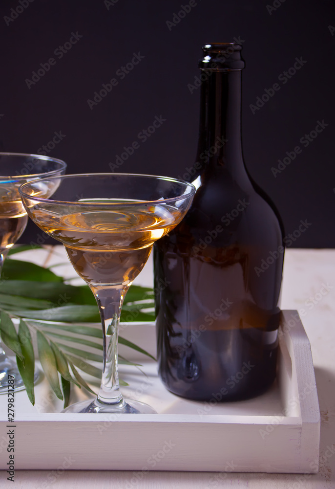 White wine in a glasses, bottle on the white wooden tray. Dinner for two. White wine in a glasses, bottle on the white wooden tray. Dinner for two.