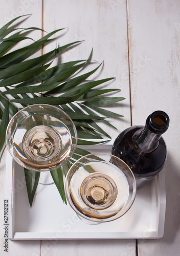 White wine in a glasses, bottle on the white wooden tray. Dinner for two. photo