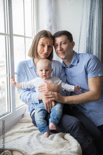 Happy Young Caucasian Family near Window