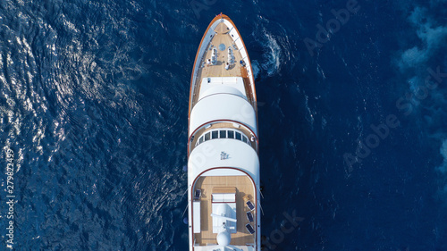 Aerial drone photo of luxury yacht with wooden deck in deep blue sea of iconic island of Mykonos near super Paradise beach, Cyclades, Greece
