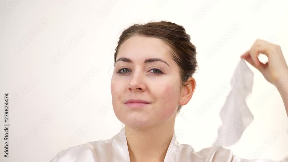 Woman removing sheet mask from her face, on white. Girl taking care of skin complexion. Beauty treatment. Skincare Woman removing sheet mask from her face, on white. Girl taking care of skin complexion. Beauty treatment. Skincare
