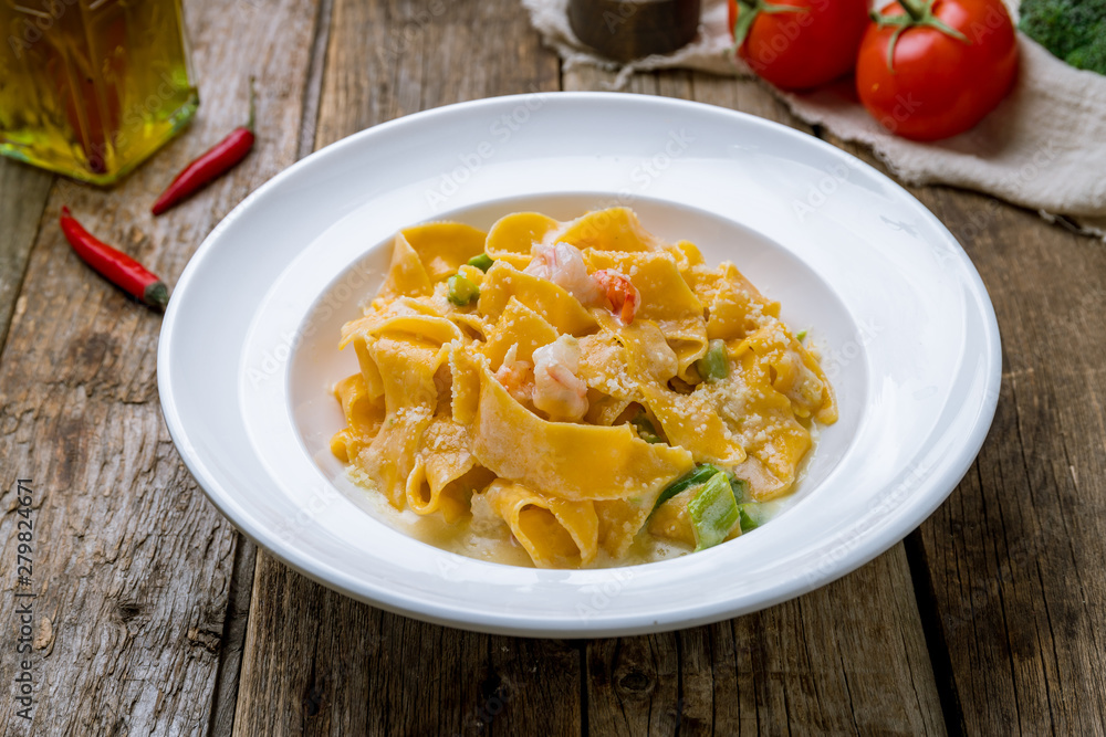 Pasta fettuccine with shrimps on wooden table Pasta fettuccine with shrimps on wooden table