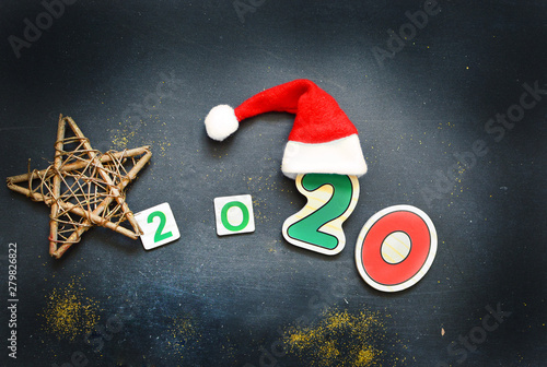 New Year 2020 pattern flat lay top view with Christmas hats, Christmas tree, star on a dark background. The concept of New Year's holidays, Christmas. New Year's holiday pattern photo