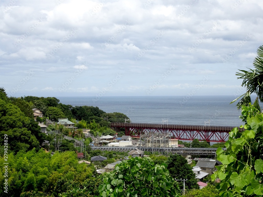 .......丘の上から見た赤い鉄橋がある海辺の町の風景