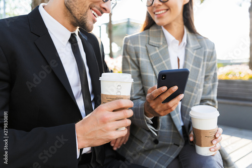 Two attractive smiling young office colleagues