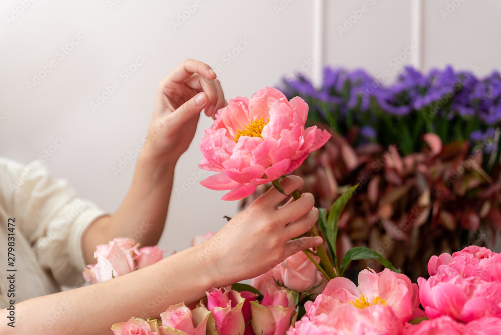 Hands of a young florist woman making modern bouquet of flowers Hands of a young florist woman making modern bouquet of flowers