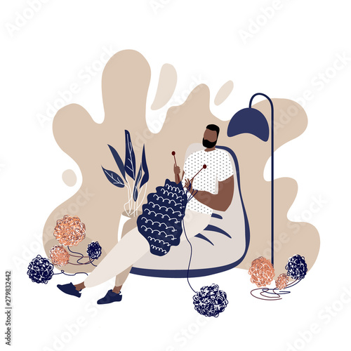 Relaxed knitting man in a cosy beanbag chair.