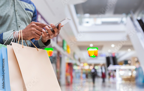 Unrecognizable african american guy with cellphone in mall