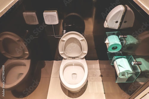 Top View Of Modern Toilet Bowl, And Toilet Paper In The Black Room is public restroom.