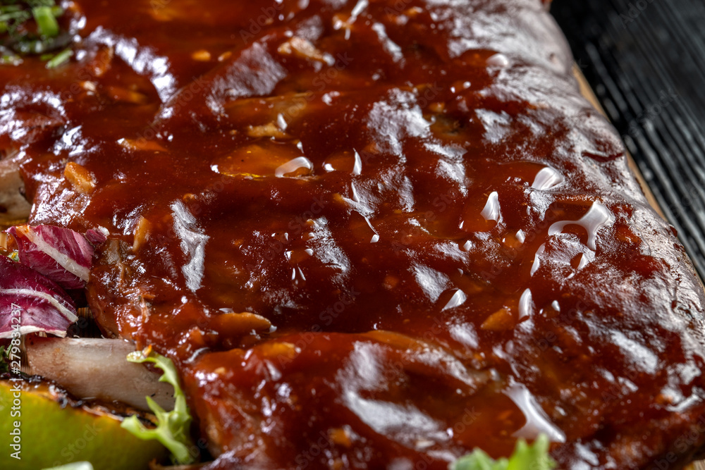 Pork ribs with sauce laid out on a wooden board. Pork ribs with sauce laid out on a wooden board.