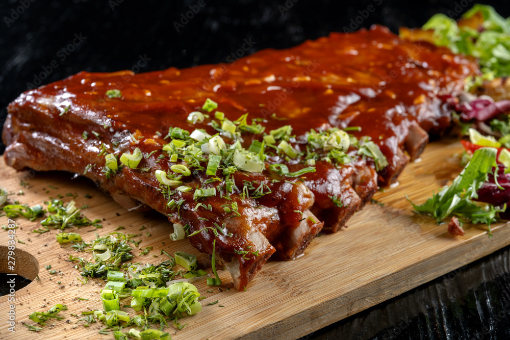 Pork ribs with sauce laid out on a wooden board. Pork ribs with sauce laid out on a wooden board.