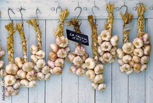 strings of garlic on old wooden background photo