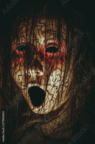 Creepy girl with black eyes opened mouth and cracked skin close-up portrait