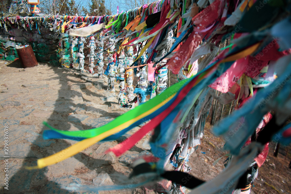 Multicolored ribbons fluttering in the wind, symbolize the fulfillment of desires. Holy shaman's place on Lake Baikal