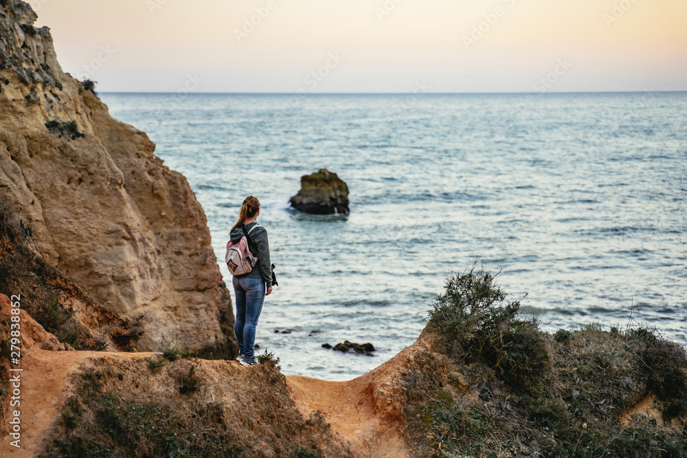 Young woman standing admiring an ocean view