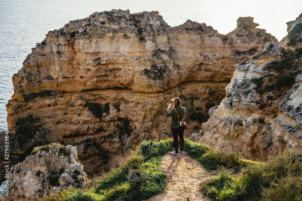 Male tourist photographing limestone cliffs