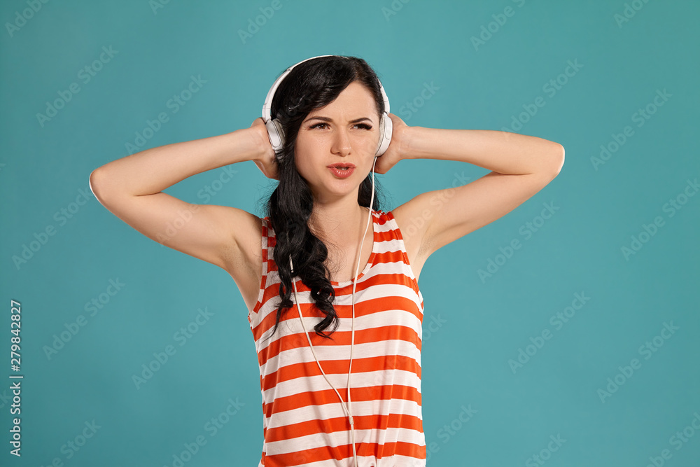 Studio photo of a gorgeous girl teenager posing over a blue background. Studio photo of a gorgeous girl teenager posing over a blue background.