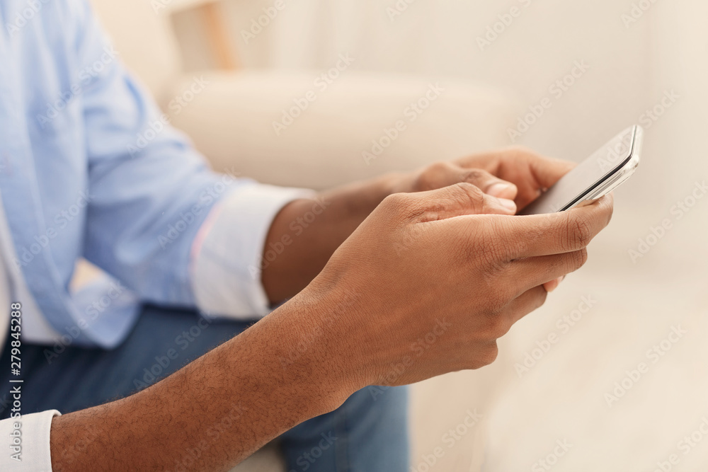 Young man using modern smartphone at home