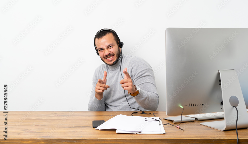 Telemarketer Colombian man pointing to the front and smiling Telemarketer Colombian man pointing to the front and smiling