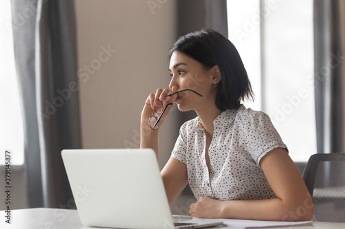 Thoughtful anxious asian business woman looking away thinking solving problem photo