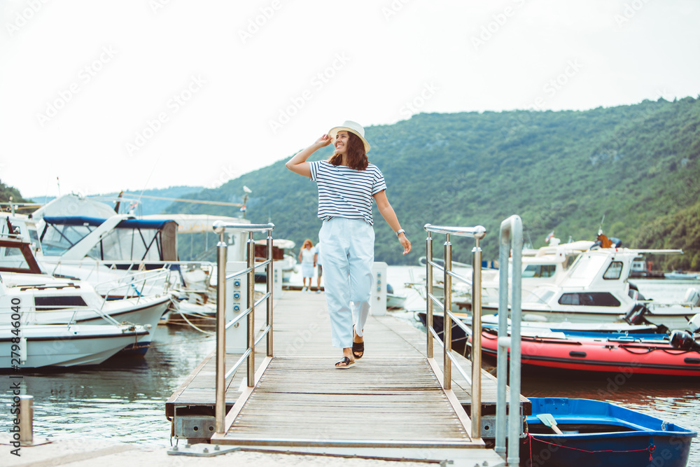 woman in white fashion luxury view walking by dock boats on background