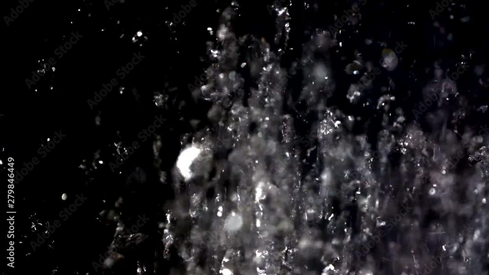 water droplets spouting out of the shower upwards against a dark background. Slow motion. water droplets spouting out of the shower upwards against a dark background. Slow motion.