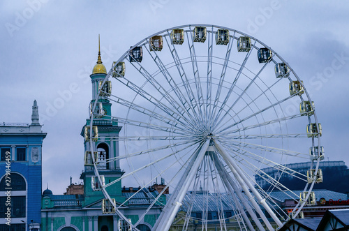 Ferris wheel on the background of the city and the cloudy sky