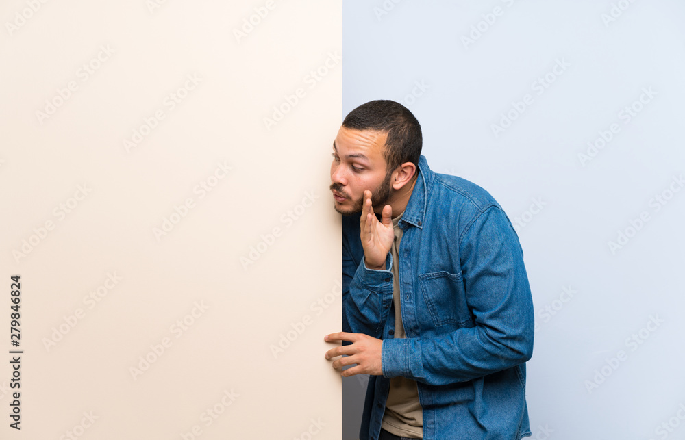 Colombian man holding an empty placard whispering something Colombian man holding an empty placard whispering something