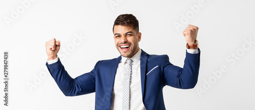 Принти на полотні Excited businessman shakes clenched fists on white studio background
