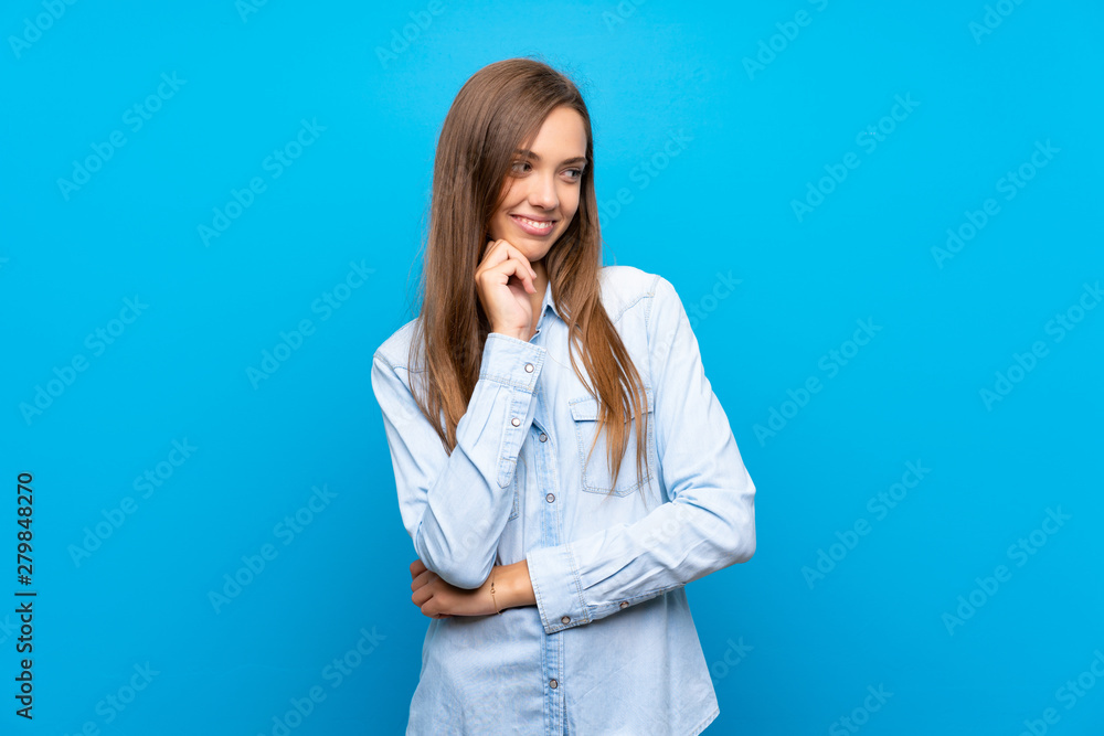 Young woman over isolated blue background looking to the side Young woman over isolated blue background looking to the side