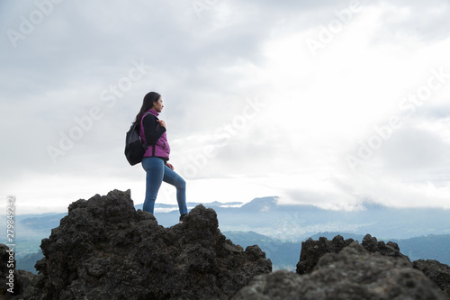 traveling woman standing on the top of a cliff overlooking the landscape- Hispanic woman