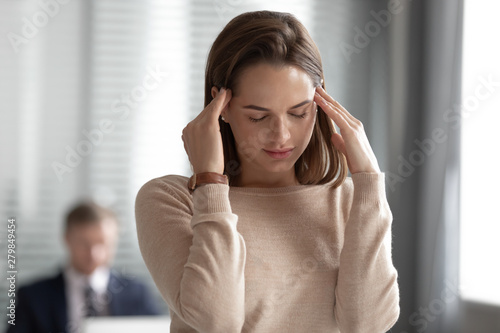 Stressed businesswoman employee manager having headache migraine in office