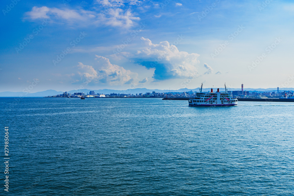 [鹿児島市の交通イメージ] 初夏の快晴の鹿児島港を背景に，桜島に向かう桜島フェリー