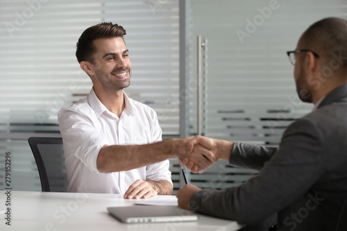 Tapet Happy male job applicant manager get hired handshaking hr client