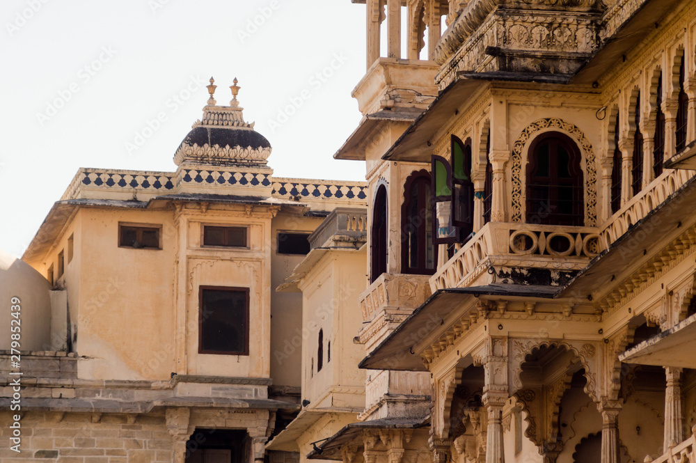 Carved sandstone exterior walls of the udaipur palace with arches, balcony and windows
