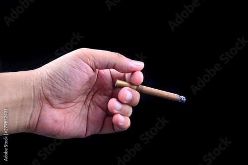 Hand holding cigar on black background
