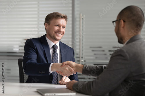 Happy diverse businessmen shake hands make business agreement at meeting