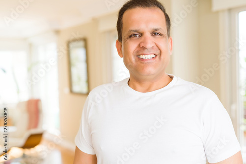 Middle age man smiling confident to the camera at home