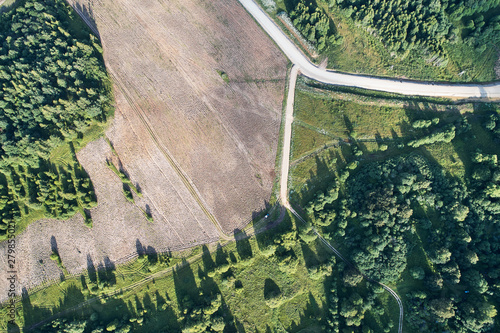 Aerial photography with a drone. Plowed field with road on the edge