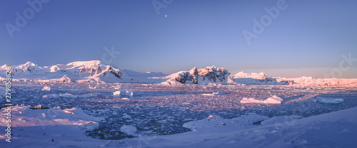 Mountain panorama of Antarctica shoreline. Amazing panoramic view. The pieces of the ice floating in the frozen ocean. Breathtaking winter landscape in the blue tints. Travel, nature, destination