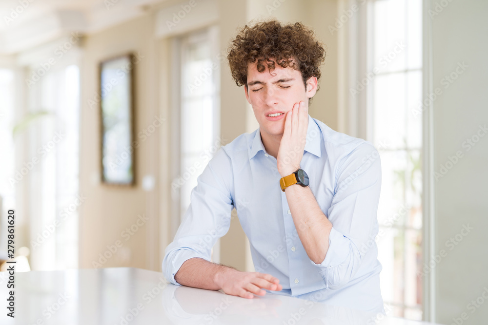 Young business man with curly read head touching mouth with hand with painful expression because of toothache or dental illness on teeth. Dentist concept.