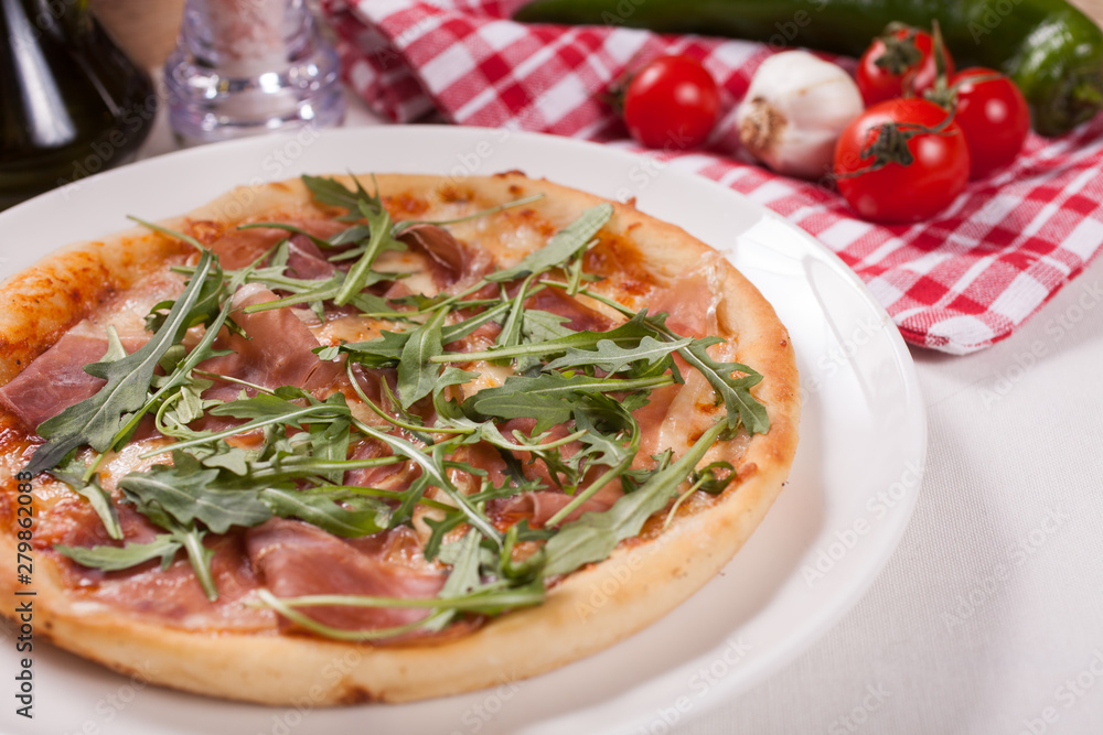 Close up of Pizza with prosciutto (parma ham) and arugula (salad rocket). Vegetables Close up of Pizza with prosciutto (parma ham) and arugula (salad rocket). Vegetables