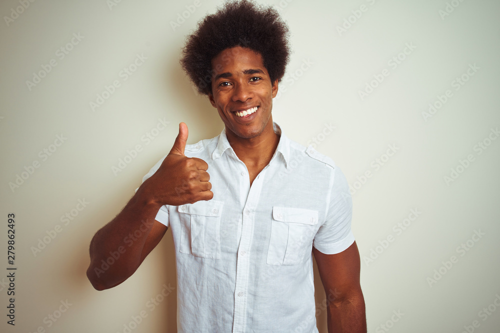 African american man with afro hair wearing shirt standing over isolated white background doing happy thumbs up gesture with hand. Approving expression looking at the camera with showing success. African american man with afro hair wearing shirt standing over isolated white background doing happy thumbs up gesture with hand. Approving expression looking at the camera with showing success.