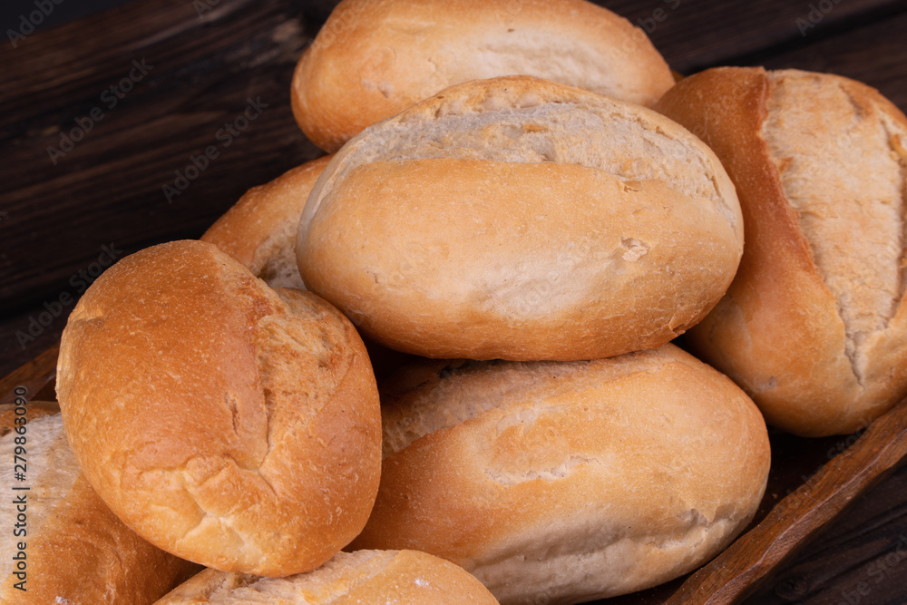 Buns in bread basket on a wooden background, low key