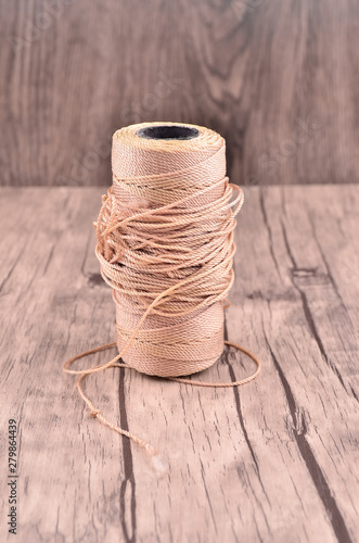 Reel of durable thread on the wooden table