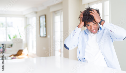 African American man at home suffering from headache desperate and stressed because pain and migraine. Hands on head.