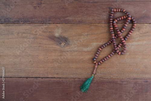 close up of wood tasbih with blur bokeh on wooden background. Wooden rosary photo