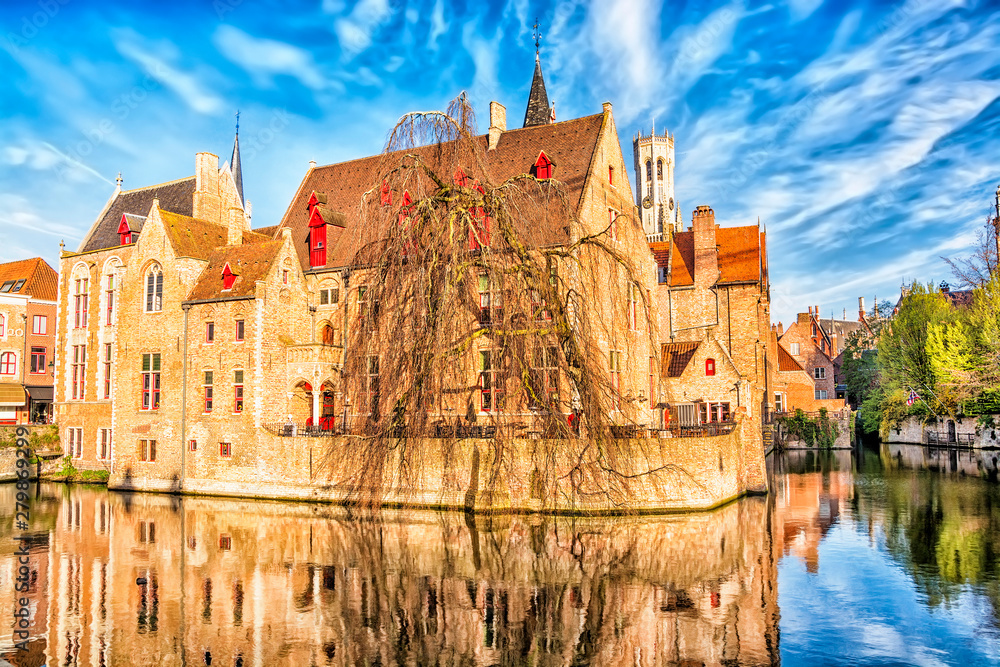 View of canal, tower Belfort and houses in medieval fairytale town Bruges at morning, Belgium